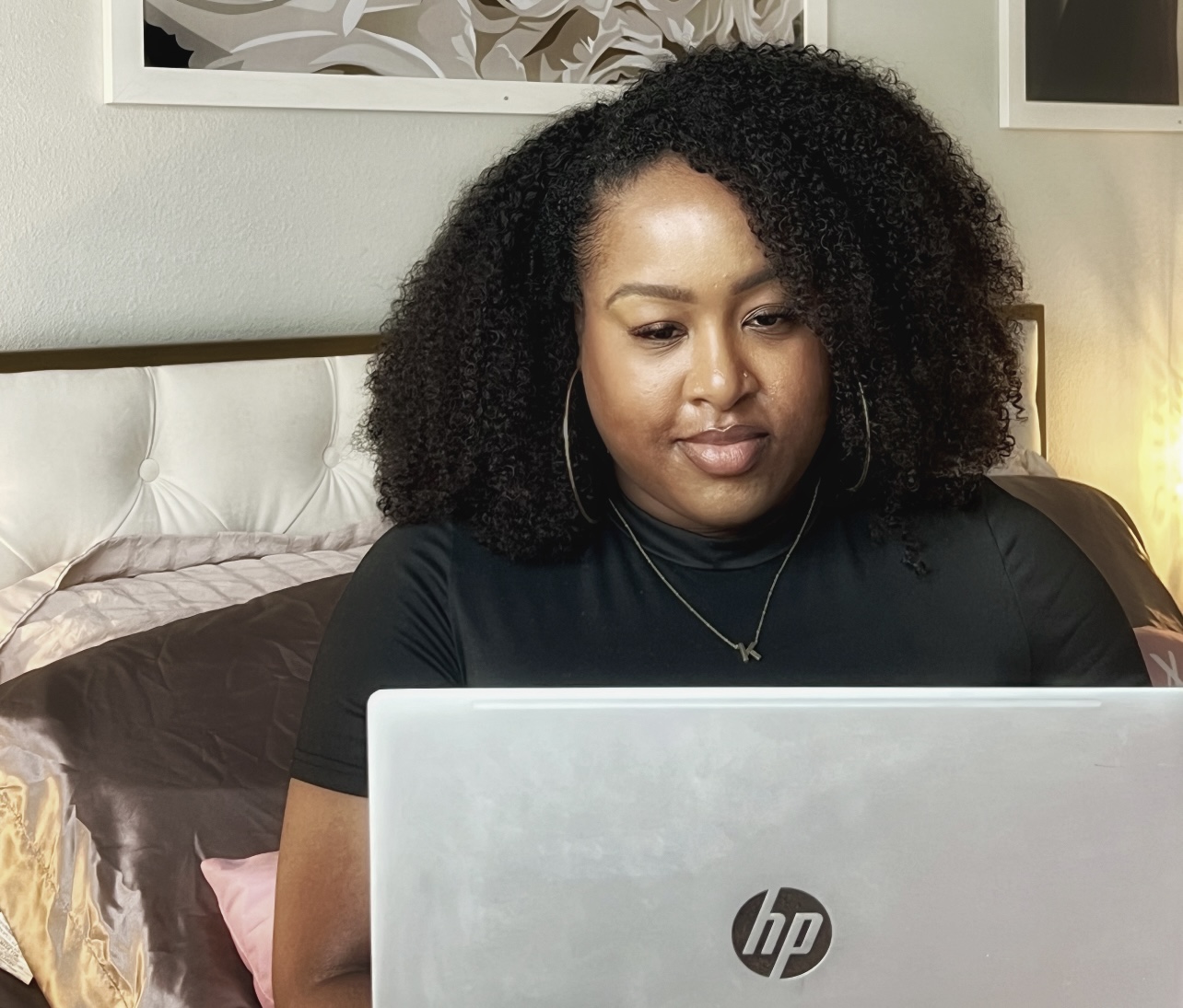 Kedra working at her laptop in her home studio